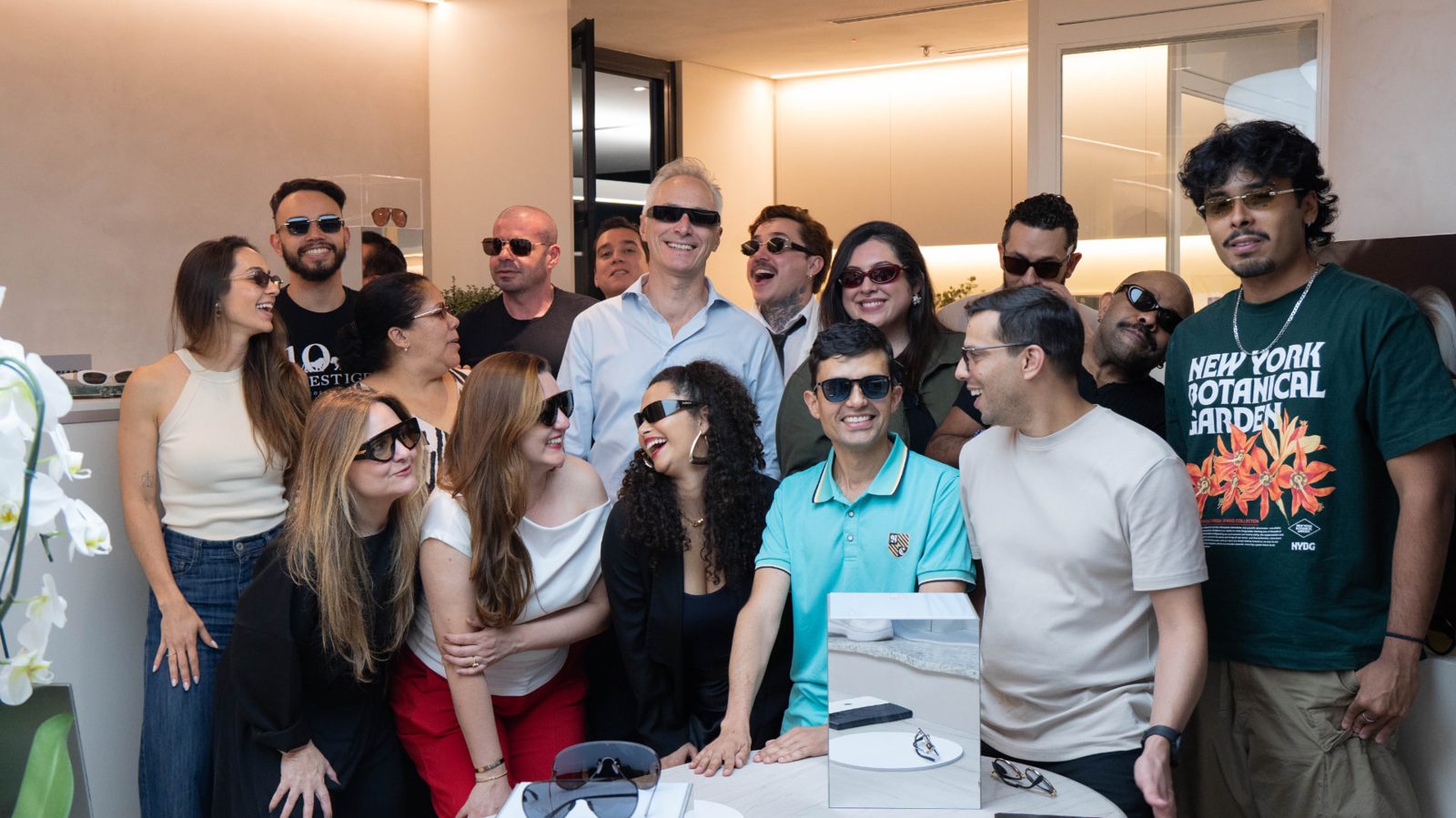 Foto de grupo com convidados e equipe Prestige usando óculos de sol